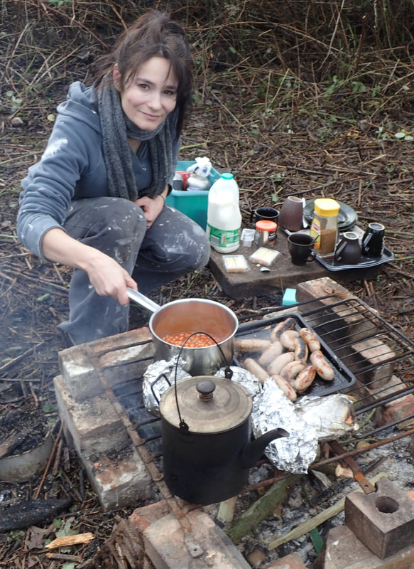 Lady cooking food over open fire